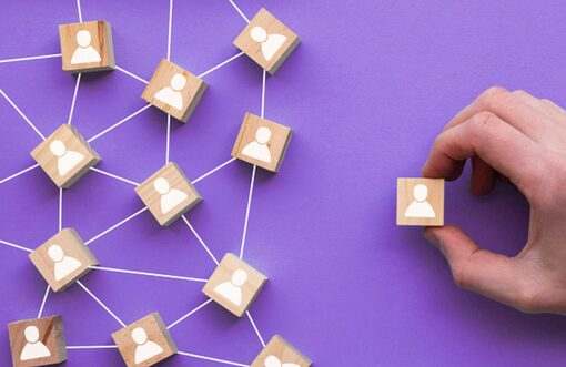 Figurines en bois reliées entre elles symbolisant le recrutement et l’esprit d’équipe