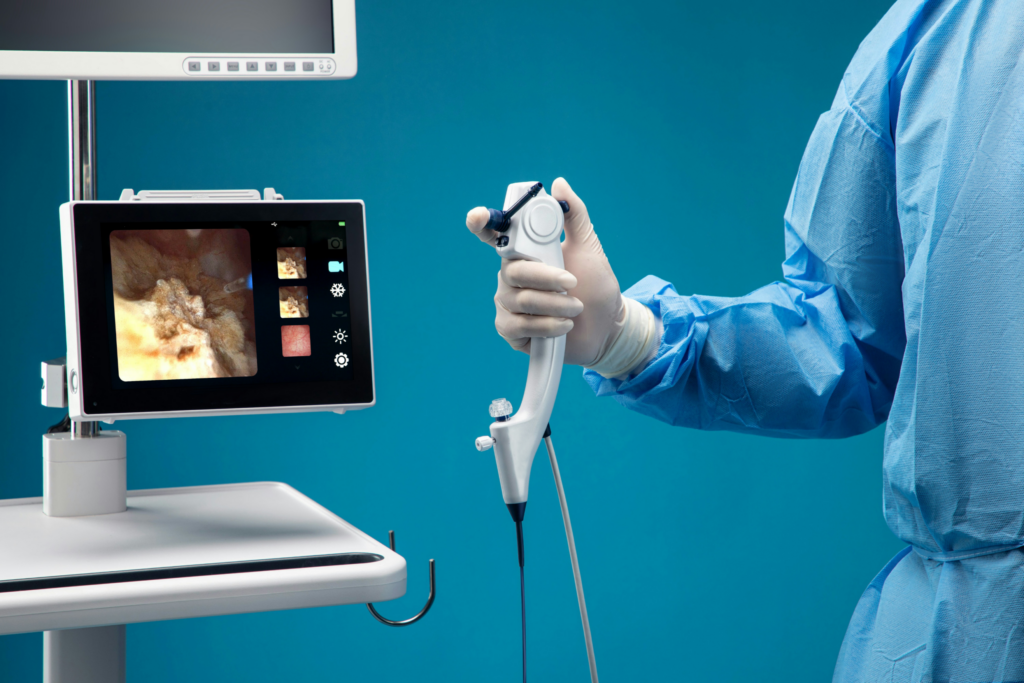 Chirurgien tenant une caméra endoscopique avec visualisation sur un écran de vidéo management.